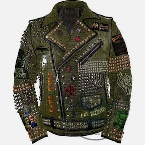 Puede incluir: Una chaqueta de cuero verde con múltiples tachuelas y parches. Los parches incluyen una calavera, una cruz y el texto "Hollywood Vampires".