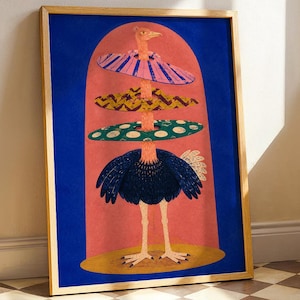 May include: A framed art print featuring a stylized ostrich standing on a yellow oval base. The bird is centered within a pink arch against a deep blue background, wearing three stacked, colorful patterned rings around its long neck.