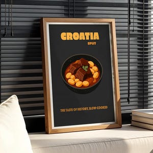 Może przedstawiać: Oprawiony plakat ze słowem "CROATIA" w pomarańczowym tekście, z grafiką ciemnej miski z gulaszem i tekstem "THE TASTE OF HISTORY, SLOW-COOKED". Butelka wina i książki znajdują się na białej powierzchni.