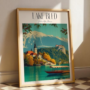 Può includere: Stampa artistica incorniciata del lago di Bled, in Slovenia, con una vista panoramica del lago, della chiesa e del castello. La stampa ha una cornice in legno e include il testo "LAKE BLED" e "Julian Alps, Slovenia". L'opera d'arte presenta una barca sul lago.