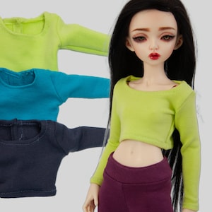 May include: Three long-sleeved shirts in different colors: lime green, teal blue, and dark gray. The shirts are cropped and have a round neckline.