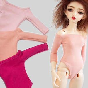 May include: Three off-the-shoulder doll leotards in pink, peach, and magenta.
