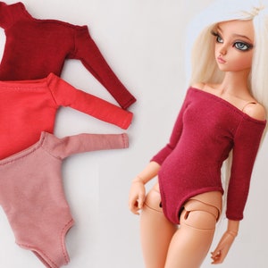 May include: Three doll-sized bodysuits in red, pink, and burgundy. The bodysuits have long sleeves and an off-the-shoulder neckline.