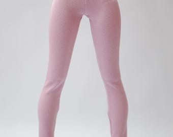 Peut inclure: Une poupée porte un legging rose clair et des baskets bleu marine avec des lacets blancs. Le legging est taille haute et ajusté. Les baskets ont des semelles blanches.