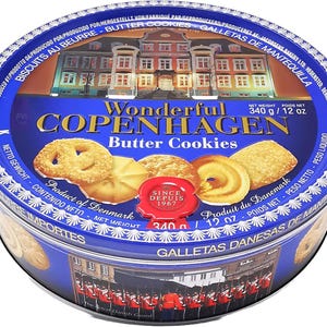 Puede incluir: Una lata redonda azul de galletas de mantequilla Copenhagen. La lata presenta una imagen de un edificio y el texto "Wonderful Copenhagen Butter Cookies". Las galletas son de color marrón dorado y tienen varias formas. Peso neto: 340 g.