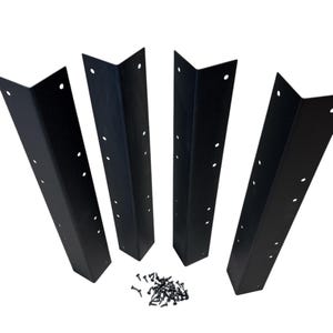 May include: Four black metal corner brackets with pre-drilled holes, arranged on a white background. A small pile of black screws is also present. These brackets are designed for structural support and are likely used in furniture or construction projects.