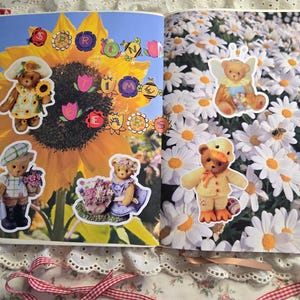 May include: A scrapbook page featuring teddy bear stickers. One page has a large sunflower with the word "SPRING" spelled out with flower and insect stickers. The other page has teddy bear stickers among white daisies.