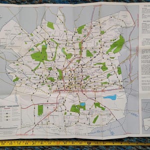May include: Folded map of Johannesburg, South Africa, with a detailed road network in red and black. Green areas represent parks and open spaces. Includes text in English and Afrikaans, and a Total gas station advertisement.