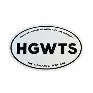 May include: Oval white sticker with black text. The sticker reads "HOGWARTS SCHOOL OF WITCHCRAFT AND WIZARDRY" around the top edge, and "HGWTS" in bold letters in the center. The bottom edge reads "THE HIGHLANDS, SCOTLAND".