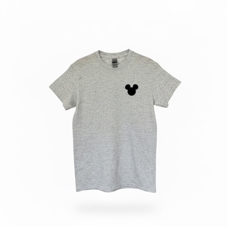 Puede incluir: Camiseta gris jaspeado con silueta negra de la cabeza de Mickey Mouse en el pecho izquierdo. Esta camiseta de manga corta est&aacute; hecha de un material suave, adecuada para uso diario.