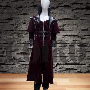 Op de afbeelding: Een lange, bordeauxrode fluwelen jas met een zwarte leren kraag en accenten. De jas heeft een ritssluiting en meerdere gespen rond de taille.