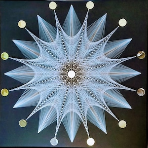 May include: A white string art mandala with a circular design and a black background. The mandala is surrounded by 12 small gold circles.
