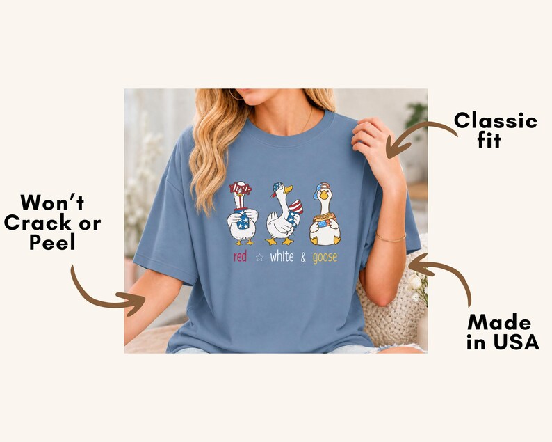 Puede incluir: Camiseta azul claro con un gr&aacute;fico de tres gansos de dibujos animados con atuendos patri&oacute;ticos. El texto "red white & goose" est&aacute; debajo. Corte cl&aacute;sico, fabricado en EE. UU.