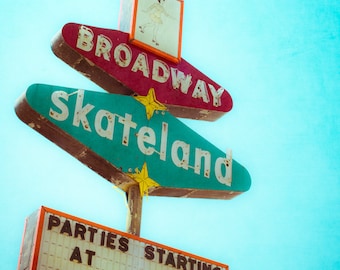 May include: Vintage sign for Broadway Skateland with a teal and red color scheme. The sign features the words "Broadway" and "Skateland" in white lettering. A smaller sign below reads "Parties Starting at $65". A retro image of a skater is on top.
