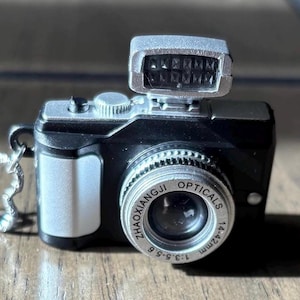 Knipperende en sluiter klinkende camerahanger