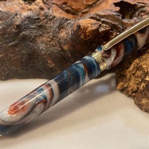 Puede incluir: Una taza de cer&aacute;mica blanca con un asa negra y el texto "But First, Coffee" en negro, en negrita. La taza est&aacute; sobre una superficie blanca.