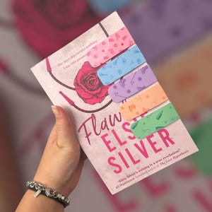 May include: A book titled "Flaw Els Silver" with colorful sticky notes. The book cover features a rose illustration and text. The sticky notes are pastel colors with small illustrations.