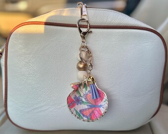 Charm para bolso con forma de concha, hecho con la técnica del decoupage.