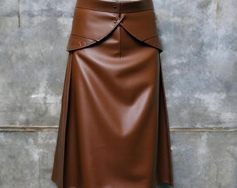 May include: A brown faux leather skirt with a high waist and a unique design featuring a layered front panel and a center seam.
