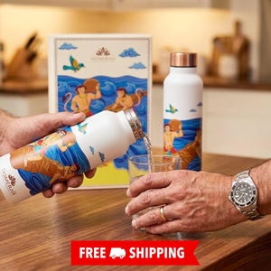 May include: Two white metal water bottles with copper-coloured caps, featuring a colourful illustration of figures in a blue ocean scene. One bottle is pouring water into a clear glass, while the other stands next to a matching rectangular box.