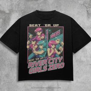 May include: Black t-shirt featuring a retro anime-style graphic. The design includes the text "BEAT 'EM UP" and "RIVER CITY GIRLS ZERO" with illustrations of anime characters in action poses. The shirt has a crew neck.