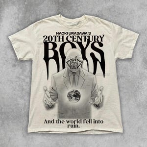May include: Off-white t-shirt featuring a graphic from the manga series 20th Century Boys. The design includes the text "NAOKI URASAWA'S 20TH CENTURY BOYS" and an illustration of a figure holding a globe. The text "And the world fell into ruin" is also present.