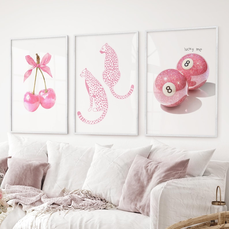 May include: Three framed art prints with pink designs. One shows two cherries with a pink bow. Another displays two pink cheetahs. The third print has two pink 8-ball pool balls with the text "lucky me".