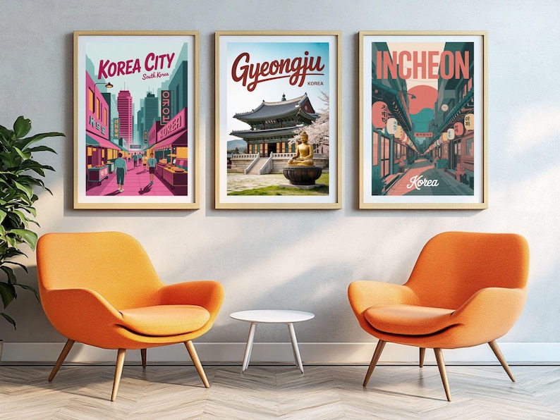 May include: Three framed travel posters with gold frames, each depicting a different South Korean city: Korea City, Gyeongju, and Incheon. The posters are displayed above two orange armchairs and a small white table.