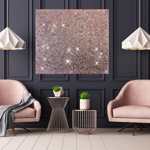 Puede incluir: Dos sillones rosas con mantas grises, dos mesas auxiliares de metal dorado con plantas y dos l&aacute;mparas colgantes de papel blanco en una habitaci&oacute;n con paredes gris oscuro y molduras blancas.