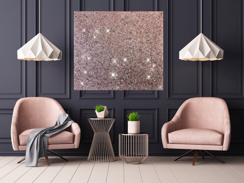 Puede incluir: Dos sillones rosas con mantas grises, dos mesas auxiliares de metal dorado con plantas y dos l&aacute;mparas colgantes de papel blanco en una habitaci&oacute;n con paredes gris oscuro y molduras blancas.