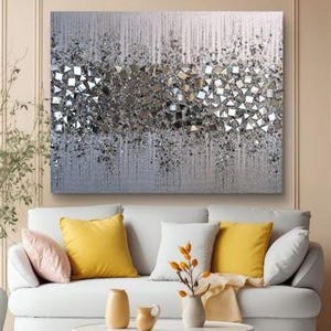 May include: A silver and gray abstract painting with a textured surface. The painting features a pattern of geometric shapes, including squares and triangles, that create a shimmering effect.