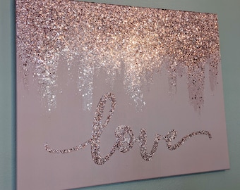 May include: A pink canvas with a glittery texture and the word "love" written in a cursive font.