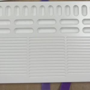 May include: A white rectangular vent cover with a series of horizontal and oval-shaped openings. The cover has a grid-like design with multiple rows of horizontal slits and a series of oval-shaped holes at the top. Four holes are in the corners.