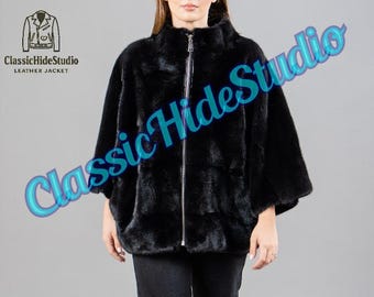 May include: A black fur jacket with a high collar and a silver zipper. The jacket has a relaxed fit with three-quarter sleeves. The Classic Hide Studio logo is in the upper left corner.