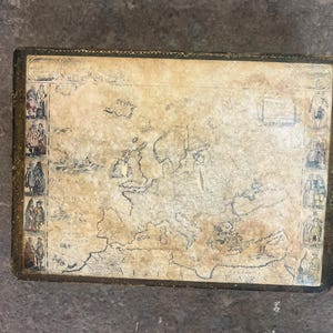 May include: A rectangular box featuring a vintage-style map of Europe and North Africa on its lid. The map is rendered in sepia tones with black outlines, flanked by vertical borders containing small illustrations of historical figures in period clothing.