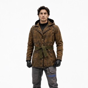 May include: A brown hooded jacket with a distressed texture and a dark olive green tie belt, worn over a black mock neck shirt. The outfit includes dark gray trousers with a blue striped accent, black leather gloves, and black knee-high boots.