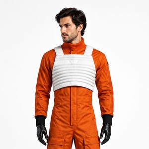 May include: A bright orange jumpsuit featuring a high collar, long sleeves with black ribbed cuffs, and multiple cargo pockets on the legs. A white, horizontally ribbed chest vest is worn over the jumpsuit, paired with black gloves and boots.