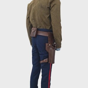 May include: A tan long-sleeved shirt paired with dark blue trousers featuring a vertical red stripe down the side. A brown leather utility belt is worn around the waist, equipped with a small rectangular pouch and a large holster on the left side.