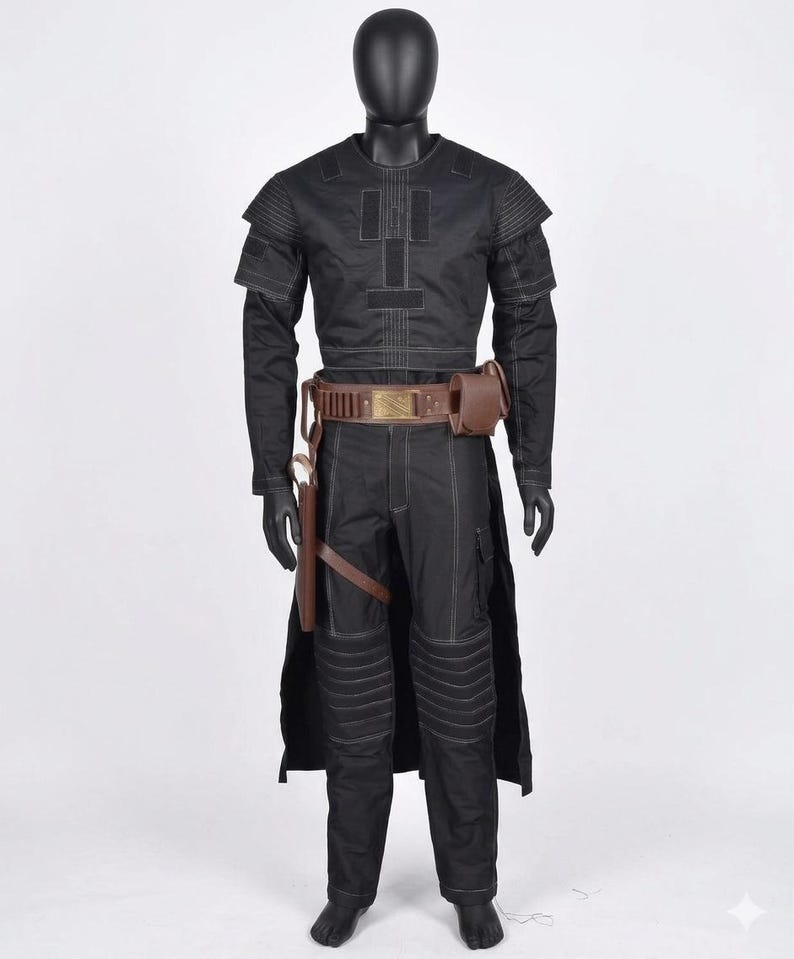 Op de afbeelding: Een zwart kostuum op een mannequin. De outfit bevat een top met lange mouwen met witte stiksels, een bijpassende broek, een bruine riem met een tasje en een holster. Het kostuum heeft een futuristische of militaire uitstraling.