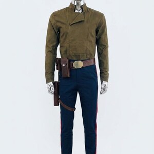 May include: A long-sleeved olive green shirt with a high collar and an asymmetrical front panel, paired with dark blue trousers featuring a vertical red stripe on each leg. A brown leather belt with a metallic buckle and attached holster is worn.