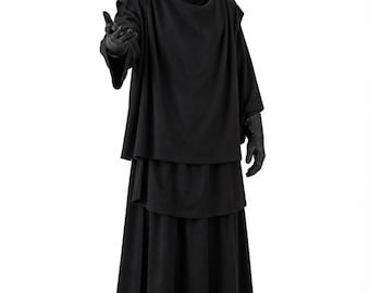 May include: A full-length black outfit consisting of a draped, high-neck tunic with wide sleeves, layered over a long, pleated skirt. The ensemble includes black gloves and a smooth, featureless black head covering, creating a monochromatic look.