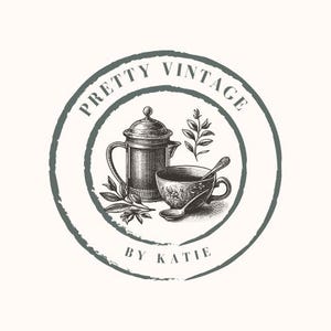 Può includere: Un logo in stile vintage con un cerchio verde e il testo "Pretty Vintage by Katie". All'interno del cerchio c'è un'illustrazione in bianco e nero di una teiera, una tazza da tè e un rametto di foglie.