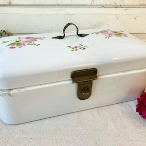 May include: A white ceramic mug with a black handle and the text "But First, Coffee" in a black, bold font. The mug is sitting on a white surface.