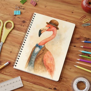 Puede incluir: Cuaderno de espiral con una ilustración en acuarela de un flamenco con bombín marrón, pajarita azul y chaqueta marrón. El flamenco tiene un cuello largo y un pico negro. El cuaderno está sobre una superficie de madera con útiles escolares.