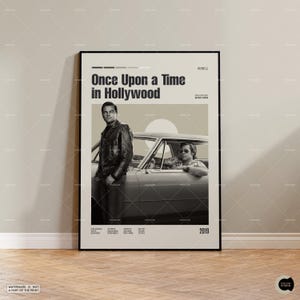 May include: Monochrome framed poster for the film "Once Upon a Time in Hollywood", featuring actors and a classic car. The poster has a neutral colour scheme and the year 2019 at the bottom. The text "WATERMARK IS NOT A PART OF THE PRINT" is at the bottom.