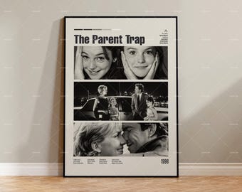 May include: A framed black and white movie poster for "The Parent Trap" (1998). The poster features images of the film's stars and the title. The poster is displayed on a wall above a wooden floor.