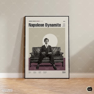 May include: A framed poster featuring the movie title "Napoleon Dynamite" in bold, black letters. The poster has a sepia-toned image of a man in a suit seated on a vintage sofa. The background includes a large, light-colored circle and a burgundy stripe.