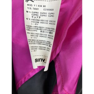 May include: A white garment care label with black text attached to a bright pink lining. The label lists the model number Y 434 80, material composition of 58% cupro and 42% viscose, and lining details. The brand name sinv is printed at the bottom.