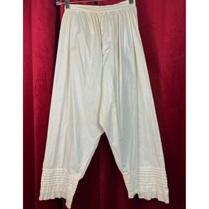 May include: White cotton undergarment with lace trim. The garment has a wide waistband and a loose fit.