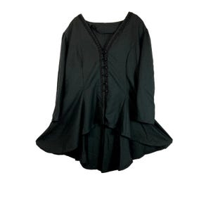 May include: A black long-sleeved top with a V-neckline and a unique high-low hemline. The top features decorative buttons down the front and delicate trim along the neckline. The fabric appears to be a lightweight material.